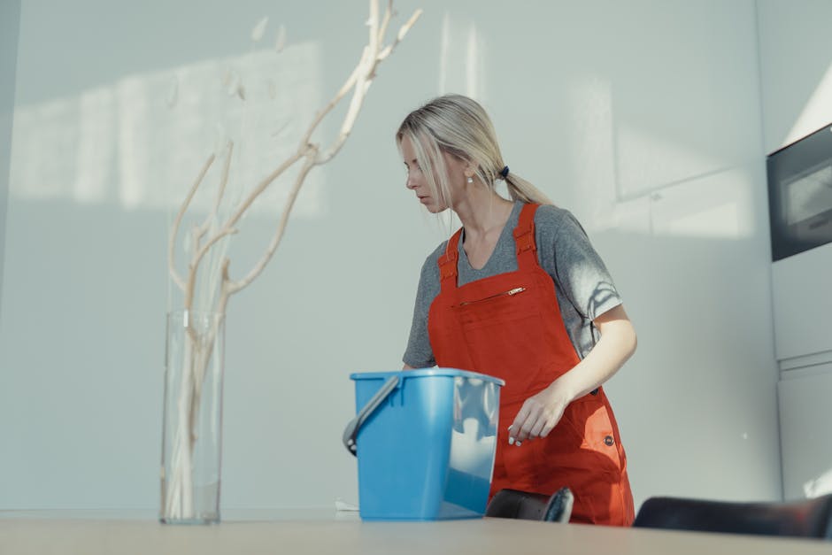 A smiling house cleaning professional organizing a tidy bedroom